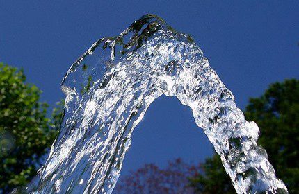 Reines Wasser aus einem Brunnen auf Sand