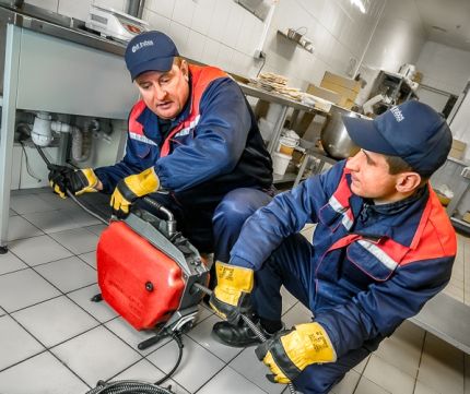 Sewerage clearing with a cable in a team