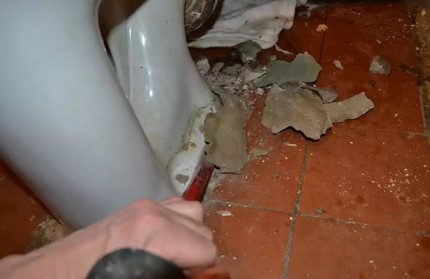 Cement neerhalen om het toilet te verwijderen