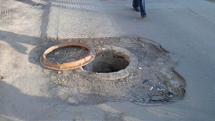 Puits d'égout ouvert sur la route