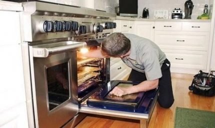 El maestro repara el horno.