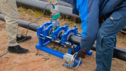 Two workers boil plastic pipes